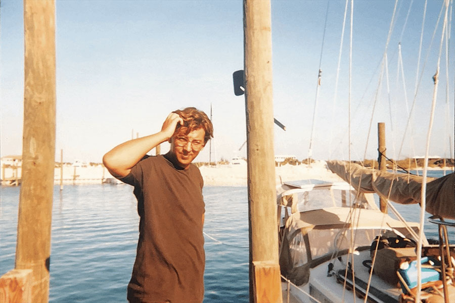 Young Marahlago founder Adrian Nixon standing by a sailing boat. The picture was taken in the 90s.